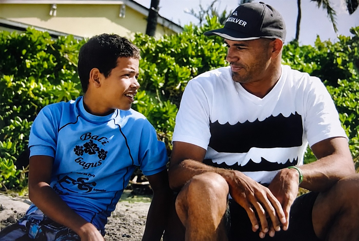 Naamã ainda criança conversando com Kelly Slater no Havaí